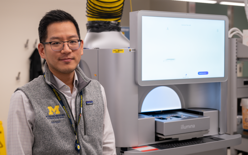 Dr. Kim with the department's Ilumina NovaSeq X, a super high throughput sequencer.